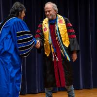 President shaking hands with faculty member